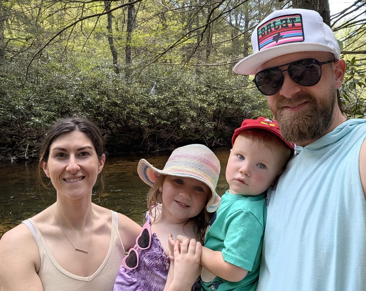 Austin with his wife and two kids by a creek